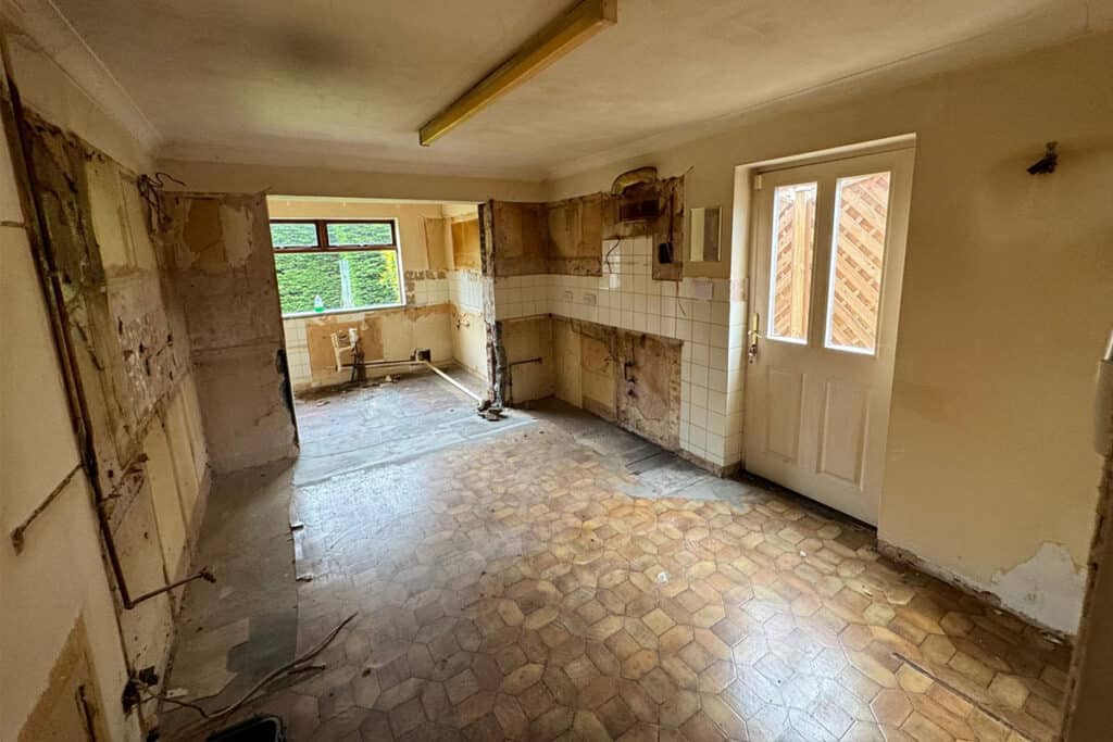 a large kitchen before being renovated that has all fixtures and fittings ripped out